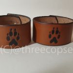 leather cuff with a wolf paw motif picked out in black with a light tan finnish