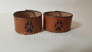leather cuff with a wolf paw motif picked out in black with a light tan finnish