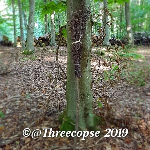 Small besom broom against a tree